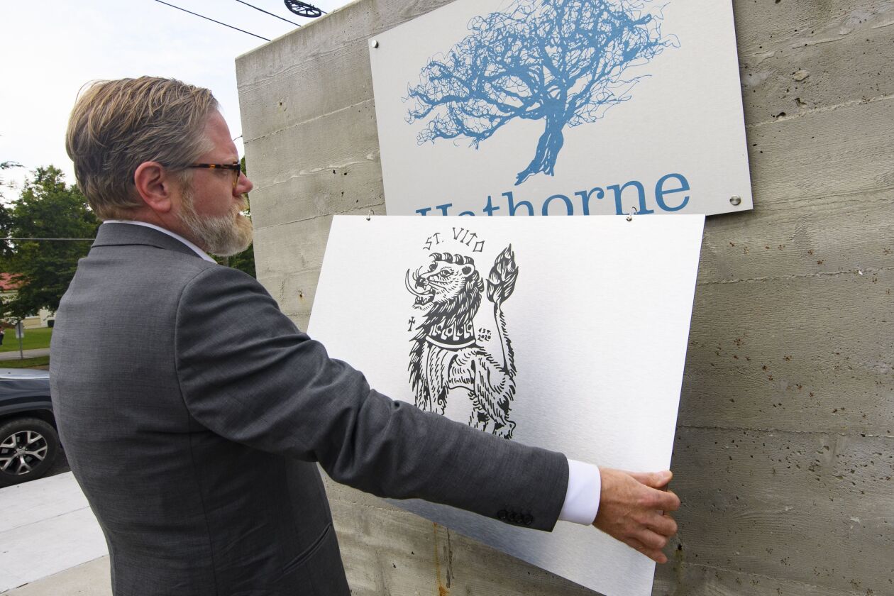 Hathorne restaurant owner John Stephenson holds a sign for a pop-up restaurant which will cover the Hathorne sign when that pop-up restaurant is open.